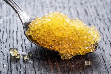 Fotobehang Pike caviar or roe in spoon on wooden background. © volff