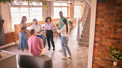 Multi-Cultural Business Team Having Informal Meeting Standing In Modern Open Plan Office Together - 757260693