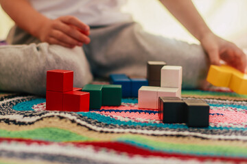 wooden logic game in the form of cubes close-up and a boy playing with it