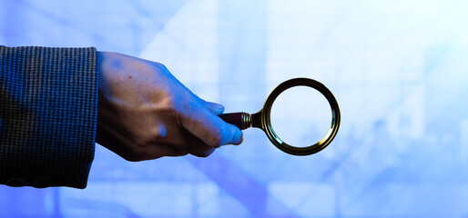 Cg tech collage. A female hand holds a magnifying glass on a light technological background