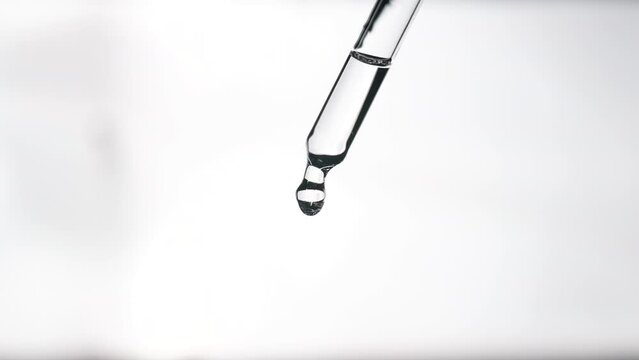 Pipette with cosmetic oil close up on a white glowing background. Cosmetic procedures. Serum