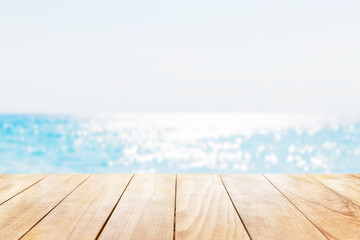 Old wooden table with turquoise water and blue sky background. Empty ready for your product display montage.