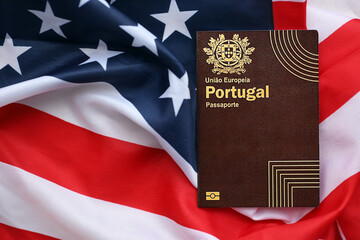 Red Portugal passport of European Union on United States national flag background close up. Tourism and diplomacy concept