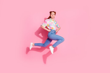 Full length size photo of freedom young attractive smiling girl touch waist jumping posing and running isolated on pink color background