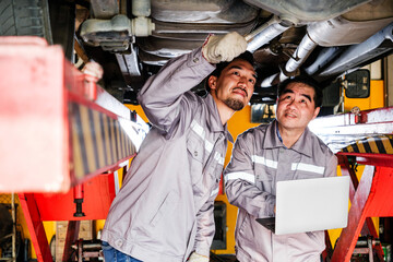 Diversity mechanic teamwork, a Thai and Japanese man in yellow and blue uniforms. A Thai man...