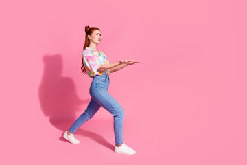 Full size photo of gloomy serious girl dressed colorful blouse jeans hold heavy object look empty space isolated on pink color background