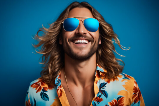 A man with long hair and sunglasses is smiling and wearing a yellow shirt with flowers. Concept of fun and carefree attitude, as the man is enjoying himself and embracing a relaxed lifestyle