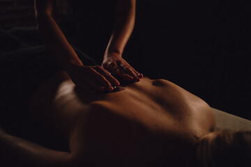 Relaxing hot stone massage therapy in a luxury spa environment with warm ambient light and massage oil on glowing skin, promoting wellness, stress relief, and deep body relaxation. © fotokutkowska