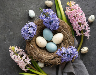 Fototapeta na wymiar top view easter nest with eggs and hyacinth flowers on concrete black background 