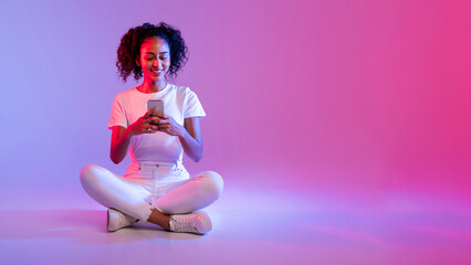 Content black woman cellphone on neon pink glow