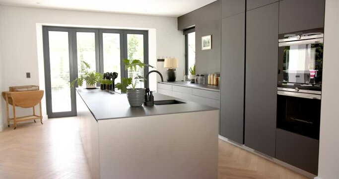 A modern kitchen features sleek gray cabinetry and a central island with a sink