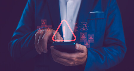 A person uses a smartphone, with a warning triangle and various caution symbols, indicating...