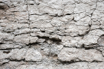 Cracked rough white rock wall, natural stone background texture