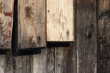 Rough wooden wall with old and new planks, background texture