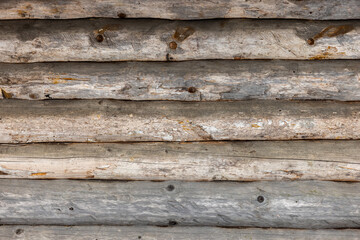 Wooden wall made of old logs, frontal background texture