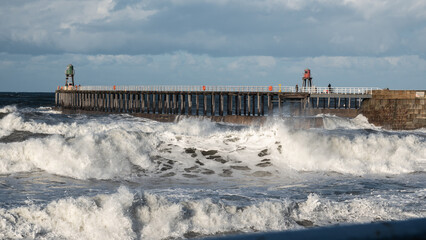 Pier with two ligthouse beacons in stormy sea