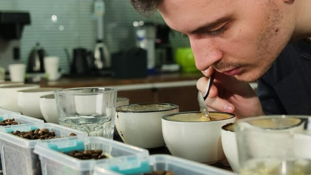 Man senses attuned to slightest variations in coffee aroma. Expert demonstrates careful exploration of coffee aromatic profile during inspection