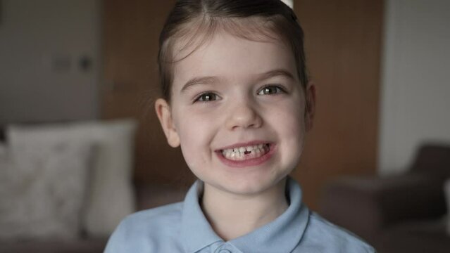 4K: Six year old girl smiles at the camera revealing a gap in her teeth to show missing tooth. Stock video Clip Footage