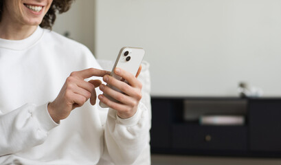 Closeup of adult male hand using mobile phone, Young man texting on smartphone over grey background - 757320678