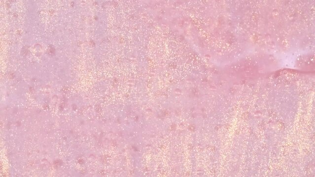 Pink Cosmetic Gel Fluid With Molecule Bubbles Flowing On The Plain White Background. Liquid Cream Gel. Macro Shot of Natural Organic Cosmetics, Medicine. Production Close-up. Slow Motion. 4k