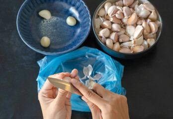 Top view of peeling garlic Preparation of ingredients for cooking, Useful herbs are often used in cooking on various occasions, homemade food preparation ideas