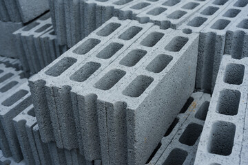 Stacks of concrete blocks ready for use in sturdy construction.  Grey concrete bricks piled, awaiting building and engineering work.