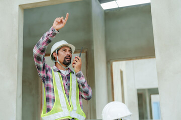 Indian construction supervisor Using radio communication Talk to foreman To order work. Man...