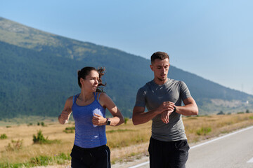 Energized by the beauty of nature, a couple powers through their morning run, their bodies and...