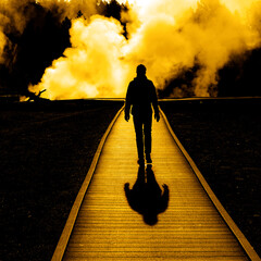 Silhouette of Tourist Walking on Boardwalk with Steam Rising