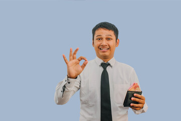 Adult Asian man smiling while holding wallet with money and give OK finger sign