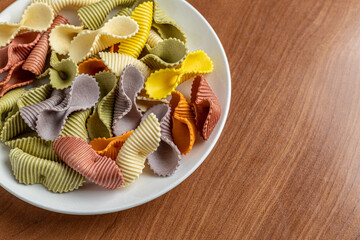 Colorful pasta background. Top view of five colors pasta shells .Heap of colorful spiral...