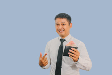 Adult Asian man smiling confident while pointing to wallet full of money that he hold