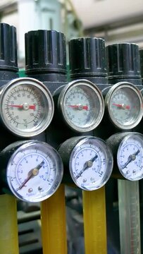 Pressure monometers on factory equipment. Pressure sensors on an industrial machine. Vertical video.