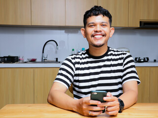 asian man smiling at the kitchen