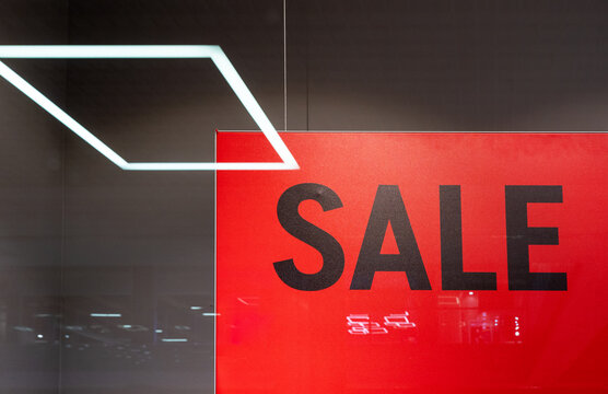 Picture of shop window display with text Sale on red poster. Shopping Sale background.