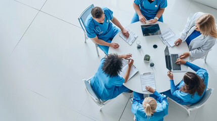 Medical team engaged in a discussion around a round table, viewed from a high angle.