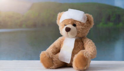 children's toy teddy bear sits with a bandaged head. Childhood trauma concept