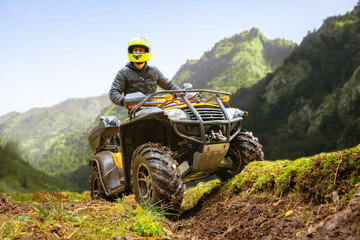 Adventurous Rider Navigating Rough Terrain on an ATV in Lush Green Mountains