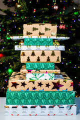 Christmas presents stacked randomly in front of the tree