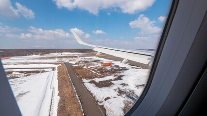 着陸している飛行機の窓から見た翼　空港の滑走路