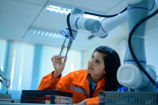 Female Robotics engineer working with Programming and Manipulating Robot Hand, Industrial Robotics Design