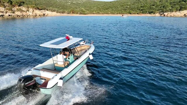 Aerial view of speedboat floating in the Aegean sea on a sunny day. Fast boat on sea surface. Sea view from drone. Travel video by yatch