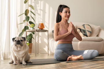 Asian woman in sportswear exercising and doing yoga with cute dog in living room at home, healthy lifestyle, Mental health concept.