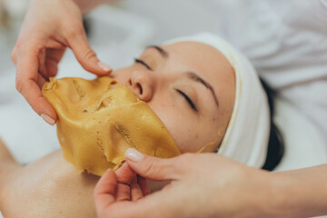  A girl at a cosmetologist does cosmetic procedures. Alginate mask