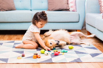 Niña bebe de 2 años jugando con bloques y su perrito
