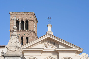 San Bartolomeo all' Isola basilica with campanile and part of the monument for Saint John in front on Tiber Island in Rome, with blue sky