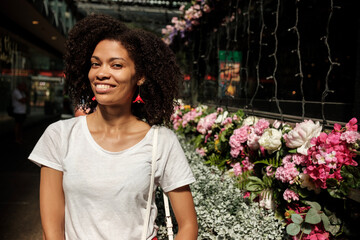 Smiling black woman in a flower street market.