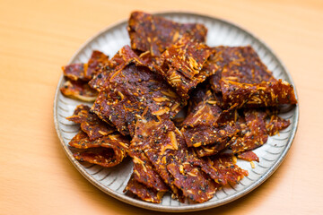 Jerky on the plate over the wooden table