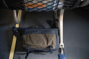 Passenger put a bag under the aircraft seat for safety flight.