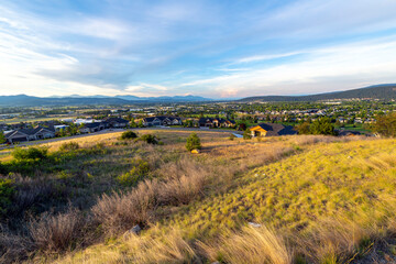 Fototapeta na wymiar Hilltop view of the states of Idaho and Washington including the cities of Liberty Lake, Spokane Valley, Post Falls and Rathdrum with late afternoon sunlight.